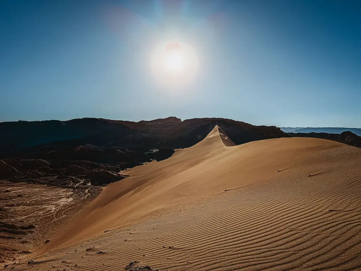 view of duna mayor at valle de la luna in chile. large orange brown dune facing the sun.