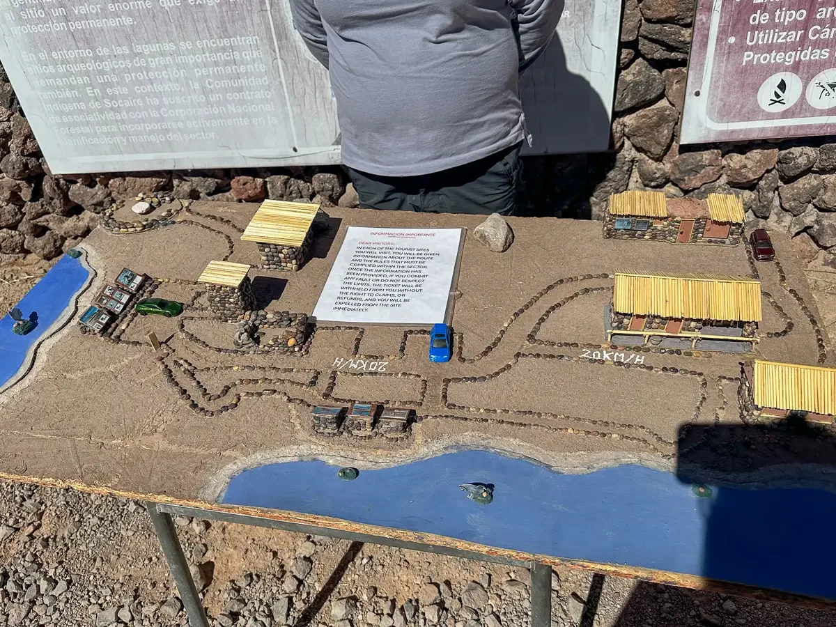 Handmade scale model of the Lagunas Miscanti reserve with toy cars and marked roads, used to brief arriving visitors on the driving route, Chile