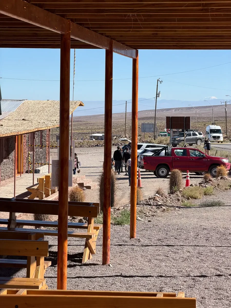 Covered waiting area and parking lot at the Socaire check-in office where visitors collect tickets for Lagunas Miscanti, Chile