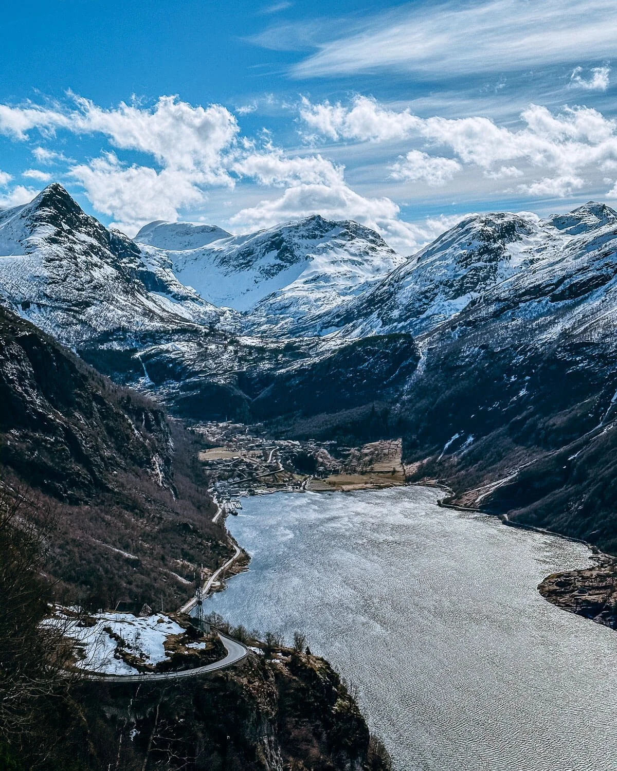 Geirangerfjord and Geiranger village from above with snow capped mountains Norway