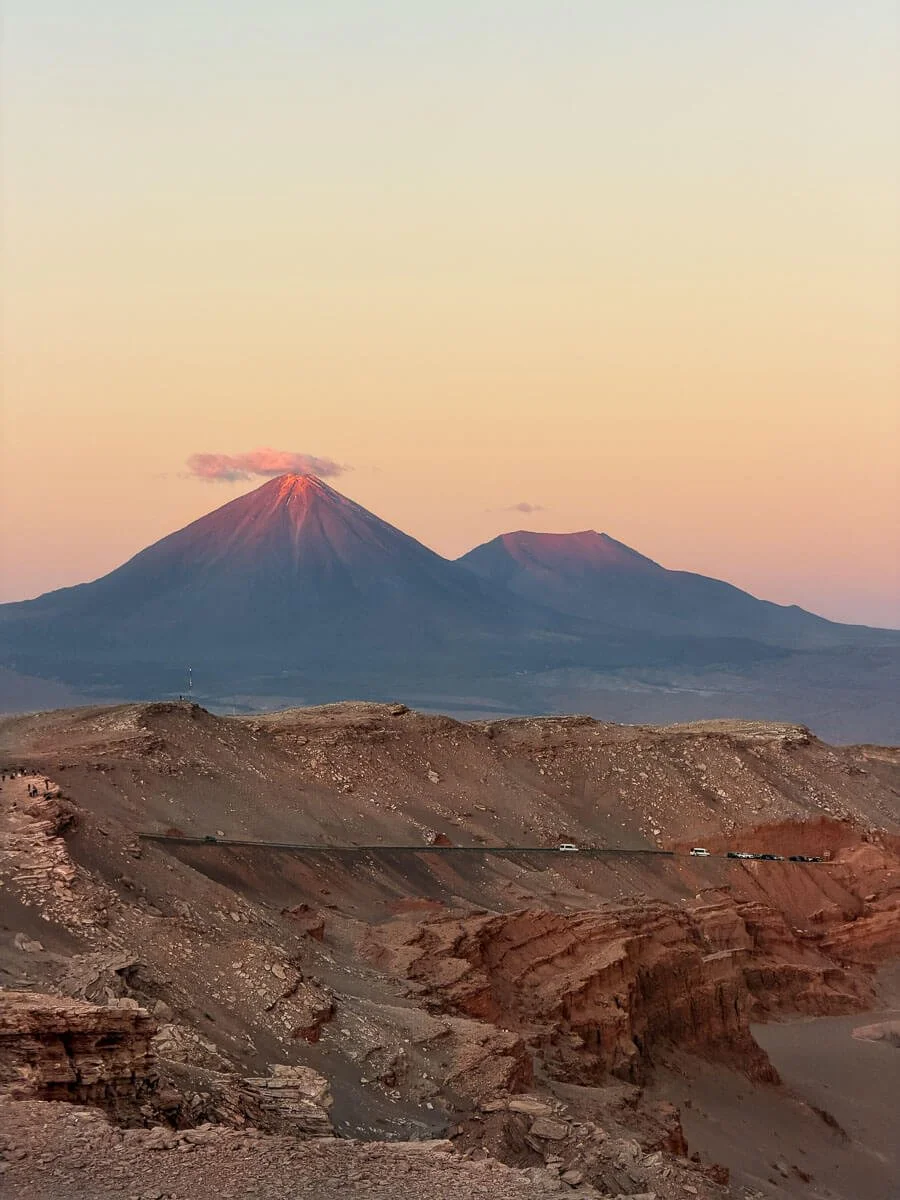 A volcano with a pink tip from the sunset in the valle de la luna park in chile