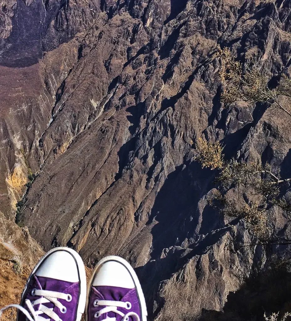 A view of the Colca Canyon in Peru with a pair of purple converse allstars in the frame.