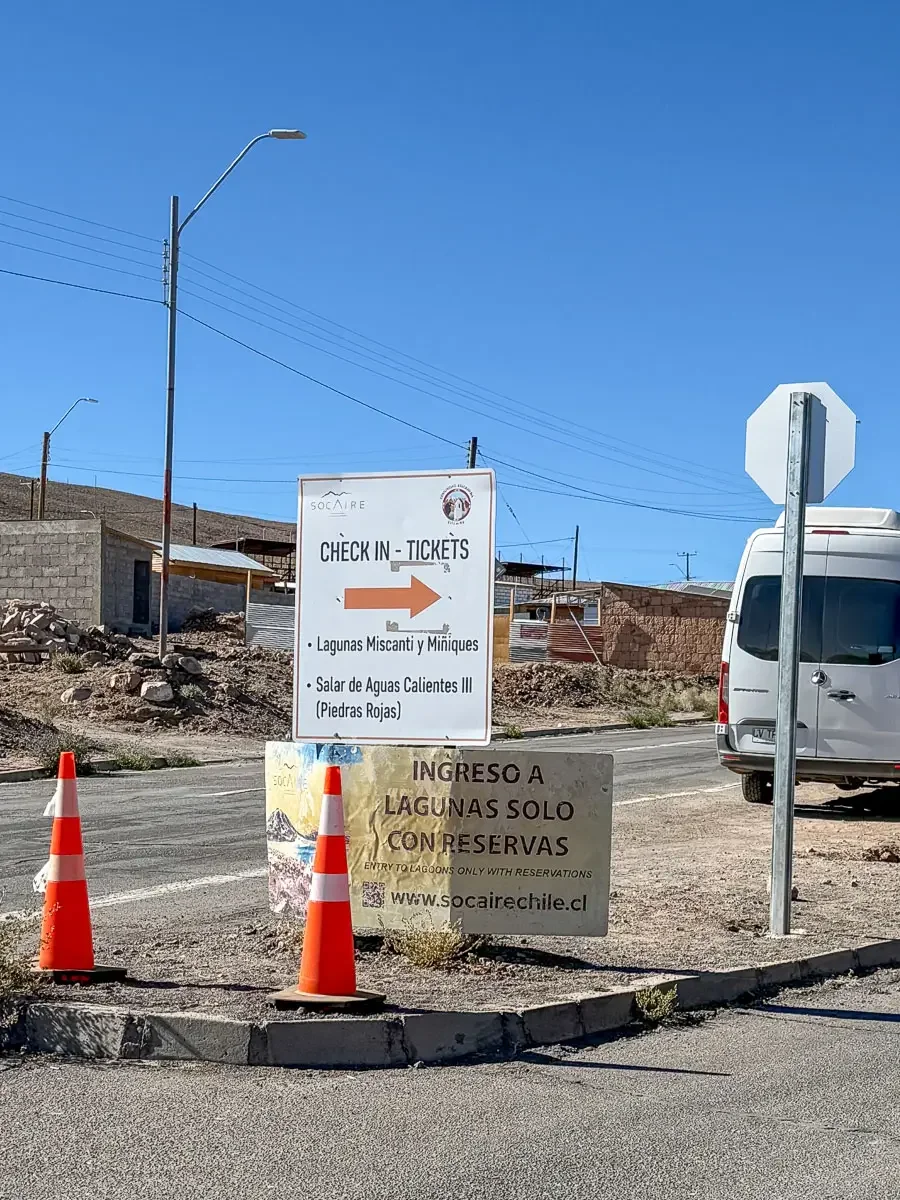 Check-in and ticket pickup sign in Socaire directing visitors to Lagunas Miscanti, Miñiques and Piedras Rojas, Chile