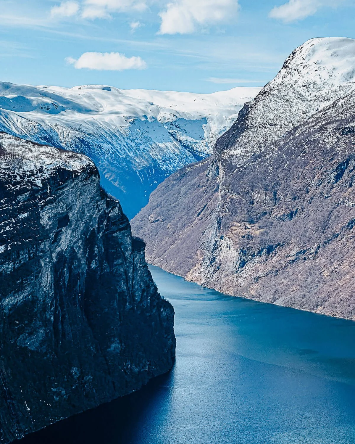Steep cliffs plunging into the deep blue water of the Geirangerfjord Norway