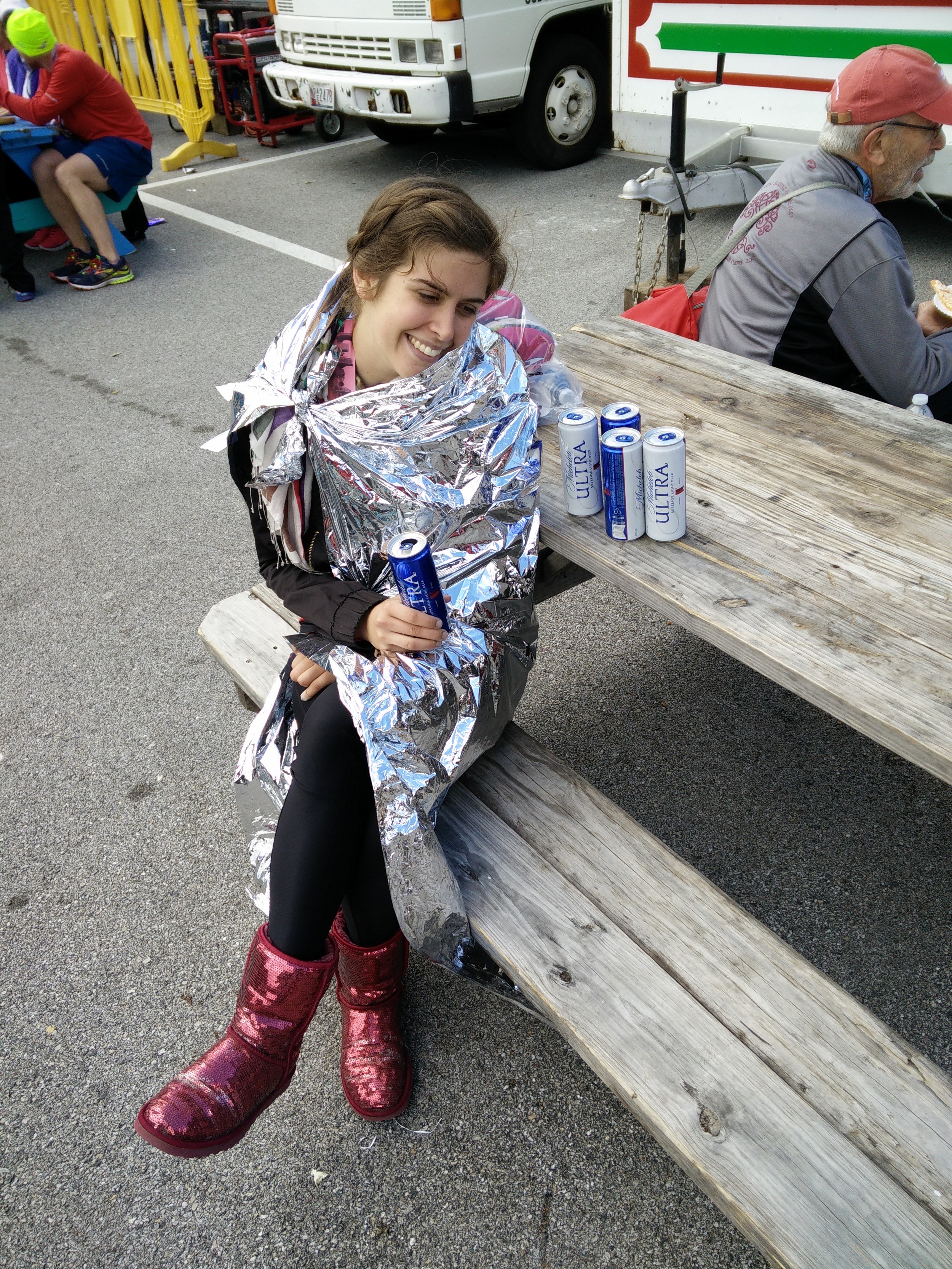 Alana chillaxin' with some free Michelob Ultra in a mylar cape and sparkly red Uggs after a PR finish.