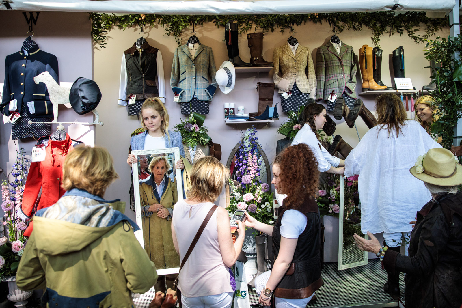  Visitors try-on and purchase clothes at a stall at the Chelsea Flower Show on May 25, 2017 in London. 