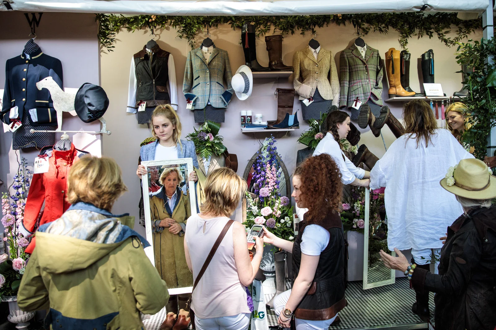 Visitors try-on and purchase clothes at a stall at the Chelsea Flower Show on May 25, 2017 in London.