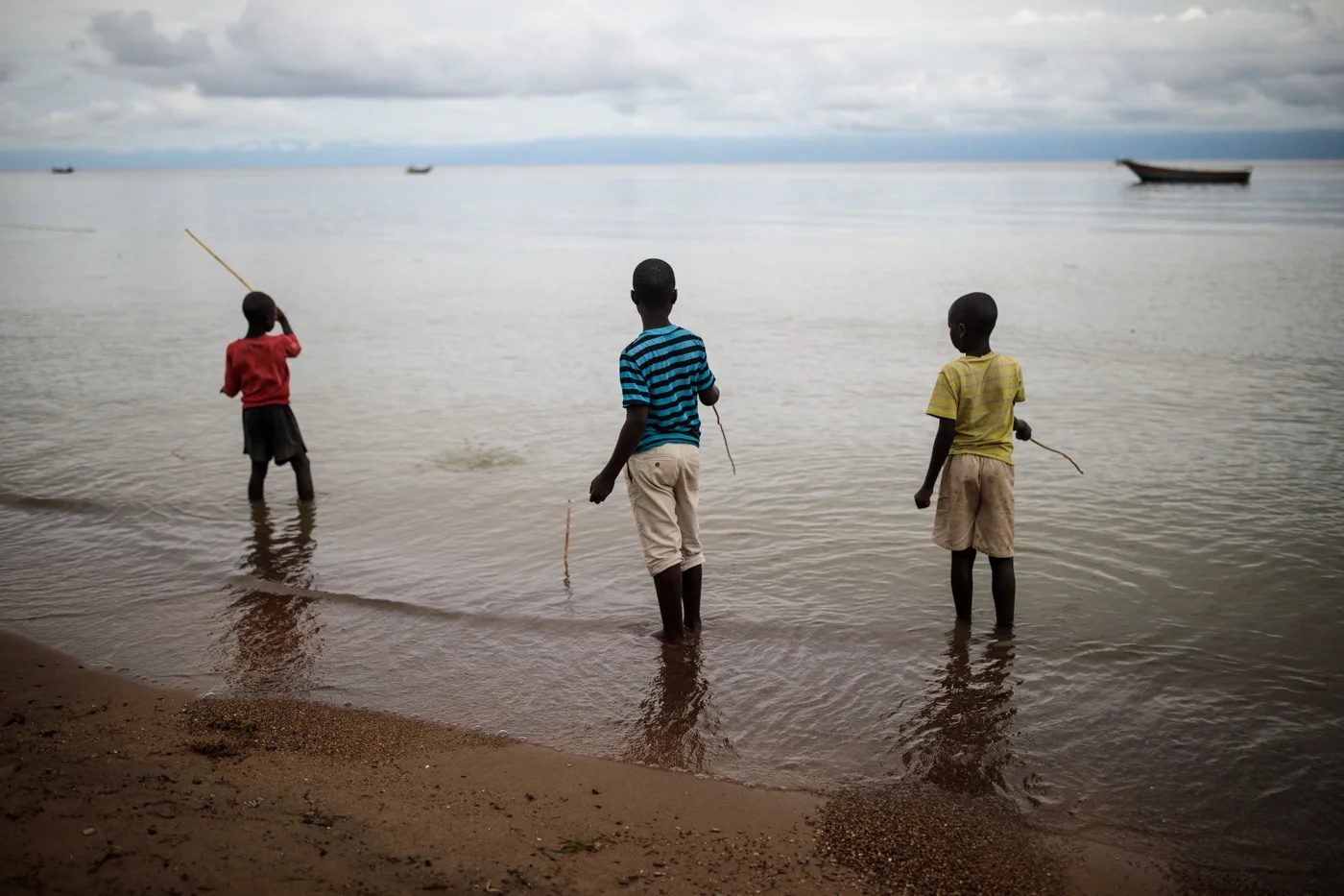 SEBAGORO, UGANDA: Local children play with home-made fishing rods on the banks of Lake Albert on April 4, 2018.