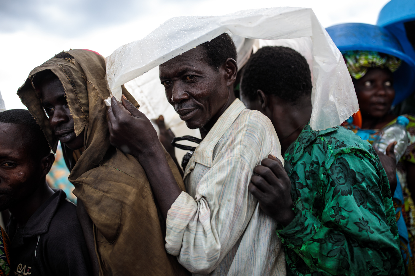 KYANGWALI, UGANDA: Refugees from the Democratic Republic of Congo shelter from the rain as they wait to receive food distributed by the World Food Programme in the Kyangwali settlement on April 10, 2018.