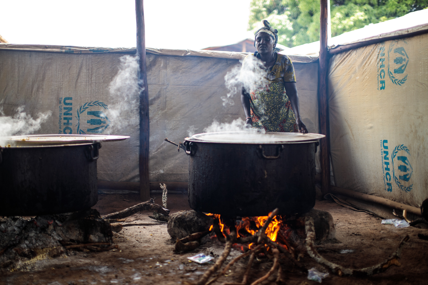  KYANGWALI, UGANDA: A volunteer helps cook food from the World Food Programme for refugees from the Democratic Republic of Congo in the Kagoma reception centre within the Kyangwali settlement on April 10, 2018. 