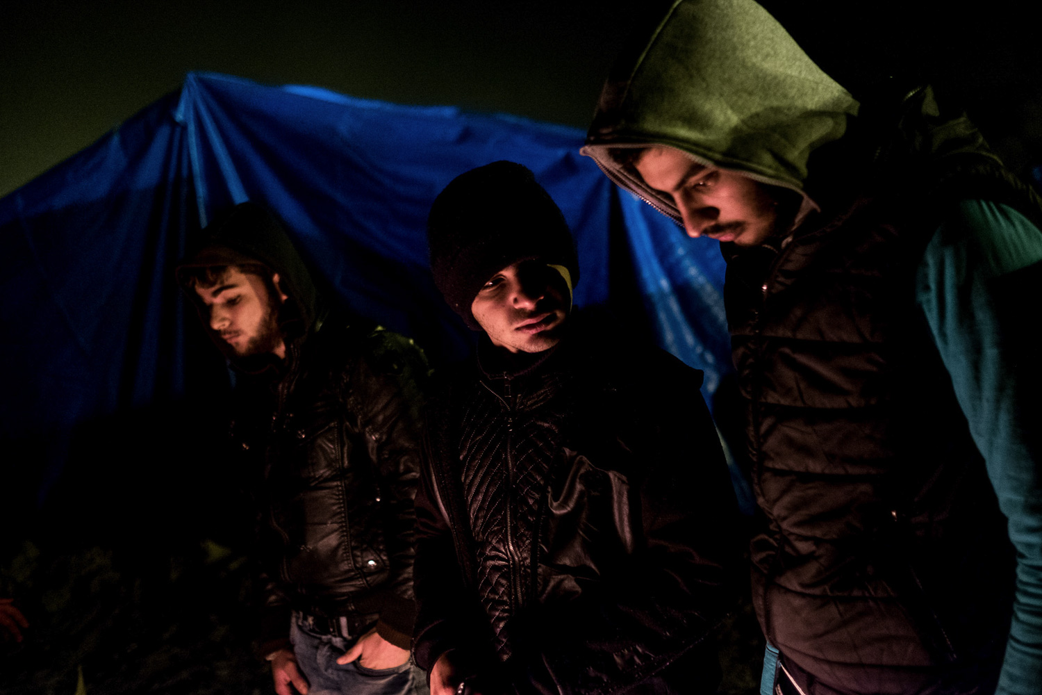 FRANCE, Calais: Syrians keep warm around a fire at the Jungle refugee camp in Calais.