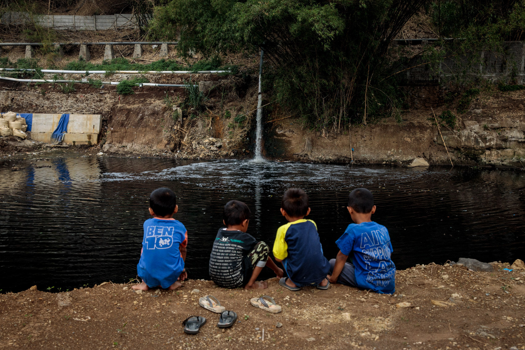  BANDUNG, INDONESIA: Boys from Jelegong village look out as waste water flows from Gistex textile factory into the Citarum River on November 20th, 2019 in Bandung, Java, Indonesia. 