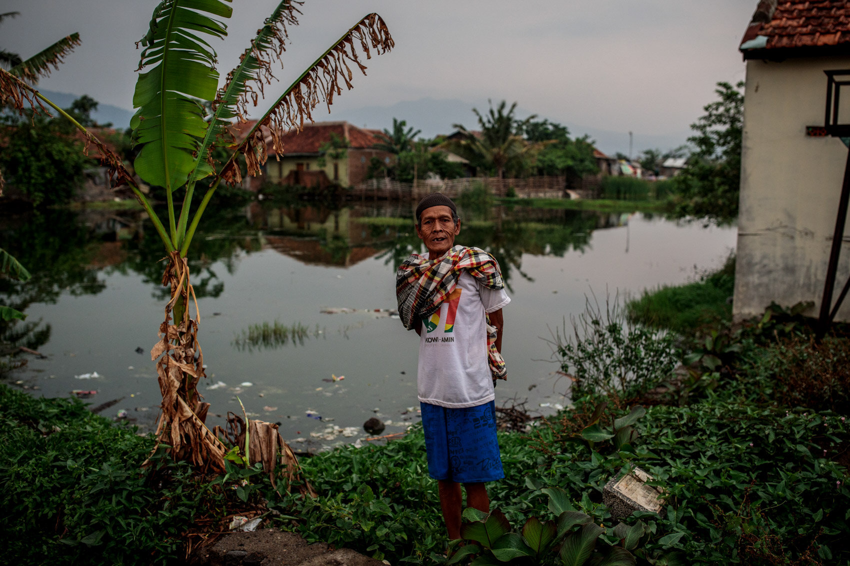  BANDUNG, INDONESIA: Former farmer Ade Traguna, 65, stands by his land, on which he can no longer grow crops as a result of the toxic water from the Citarum that was used to irrigate his rice paddies, in Jelegong village on November 23, 2019 in Bandu