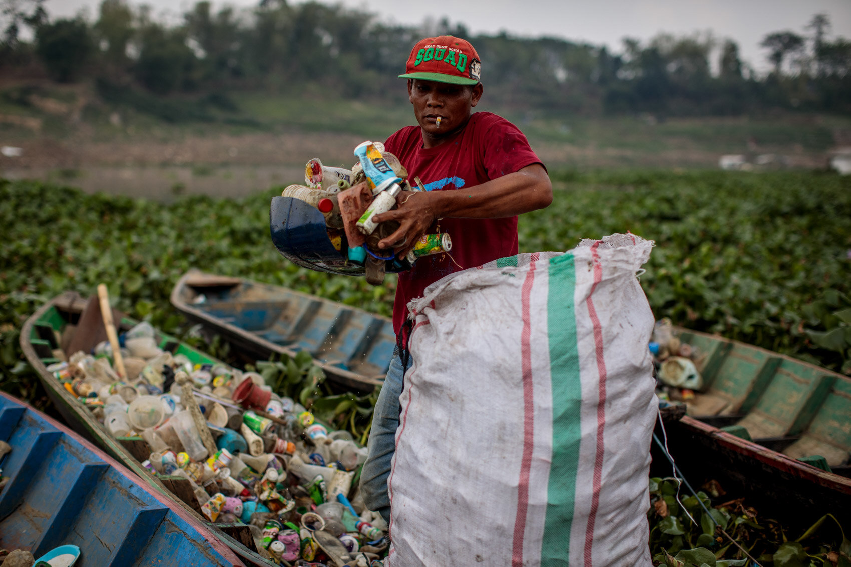  BANDUNG, INDONESIA: A man bags up plastic waste for recycling after collecting it at the Saguling reservoir on the headwater of the Citarum river on November 21st, 2019 in Bandung, Java, Indonesia. 