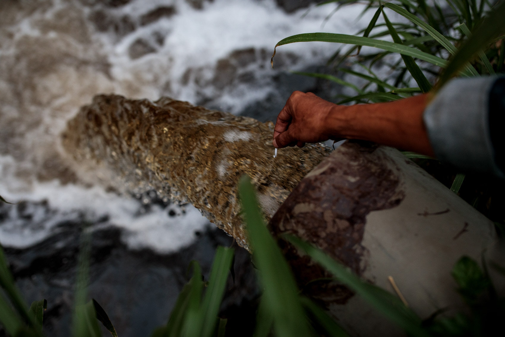  BANDUNG, INDONESIA: Environmental activist Deni Riswandani tests the PH of waste water flowing from a textile factory into a tributary of the Citarum River on November 20th, 2019 in Bandung, Java, Indonesia. 