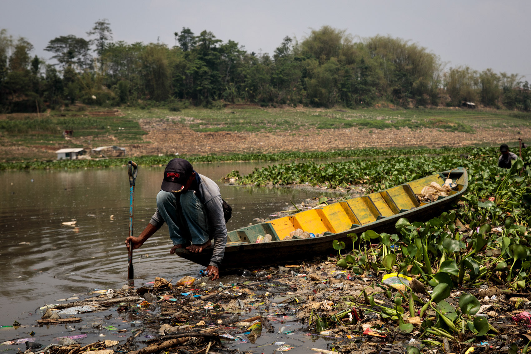  BANDUNG, INDONESIA: A man scavenges plastic for recycling at the Saguling reservoir on the headwater of the Citarum river on November 21st, 2019 in Bandung, Java, Indonesia. 