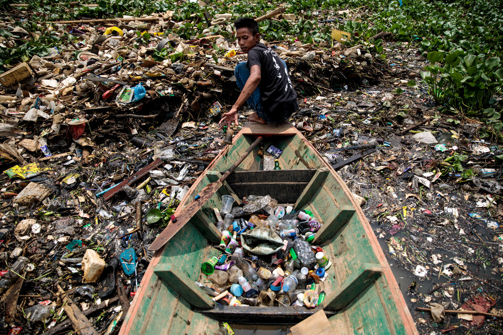  BANDUNG, INDONESIA: Plastic scavenger Rudiana, 24 from Cihampelos Village collects plastic at the Saguling reservoir on the headwater of the Citarum river on November 21st, 2019 in Bandung, Java, Indonesia. 