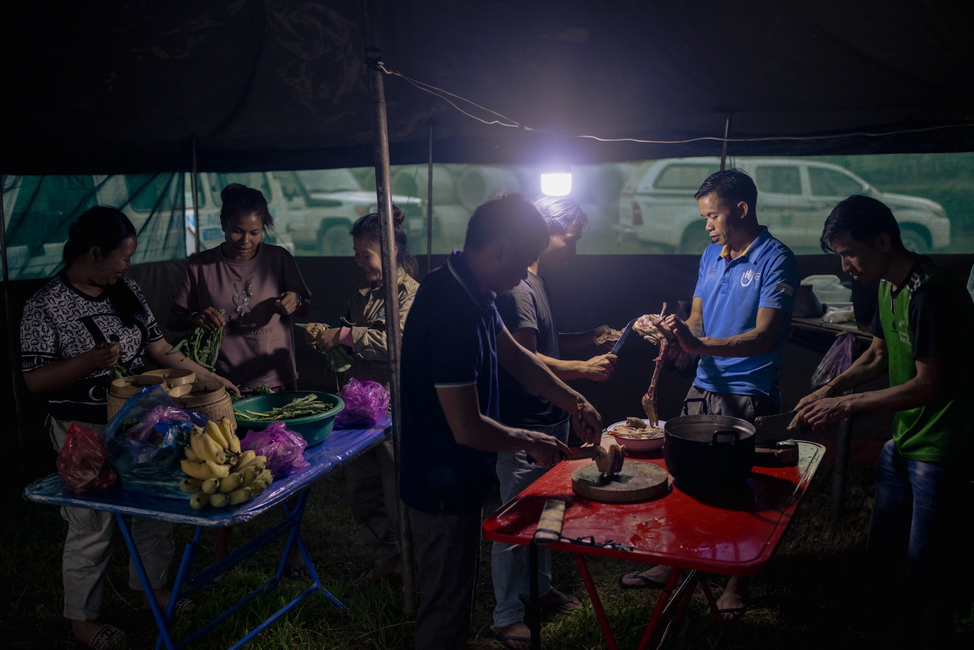  A demining team, NGO staff and local residents prepare dinner at a fly camp used for demining operations in Sop Hun. 