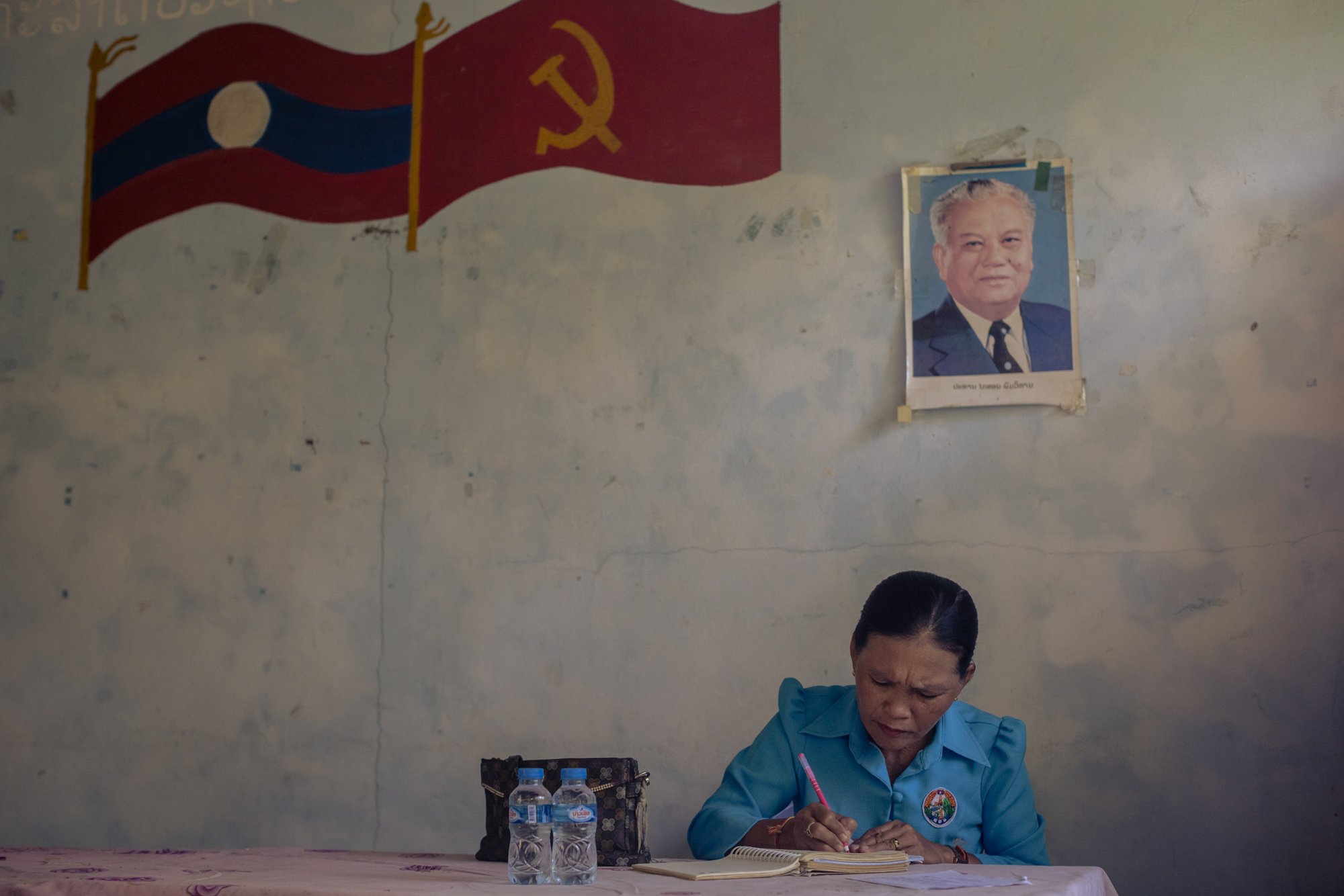  Khoa Village Chief Douavonh Xaythalar, 54 makes notes in the village hall during a meeting with residents whose land have cleared of UXOs by demining teams. 