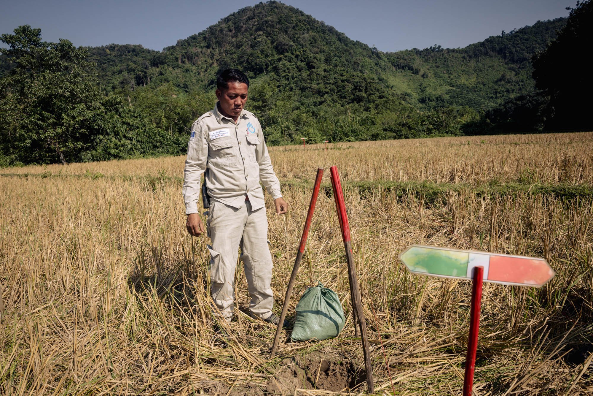  Souvan Souliman inspects an American submunition discovered in a rice paddy by field operators. 