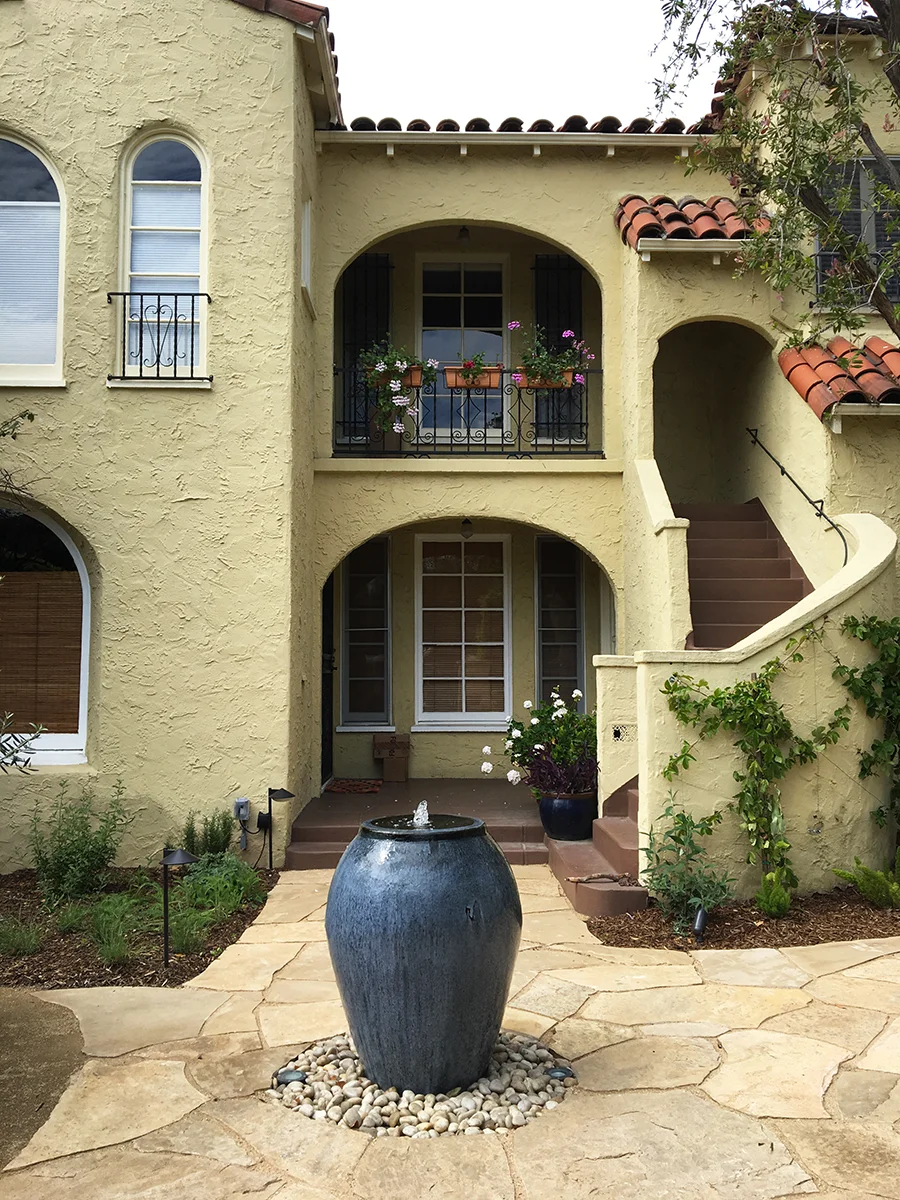 New courtyard entry with hardscape, fountain, and lighting.