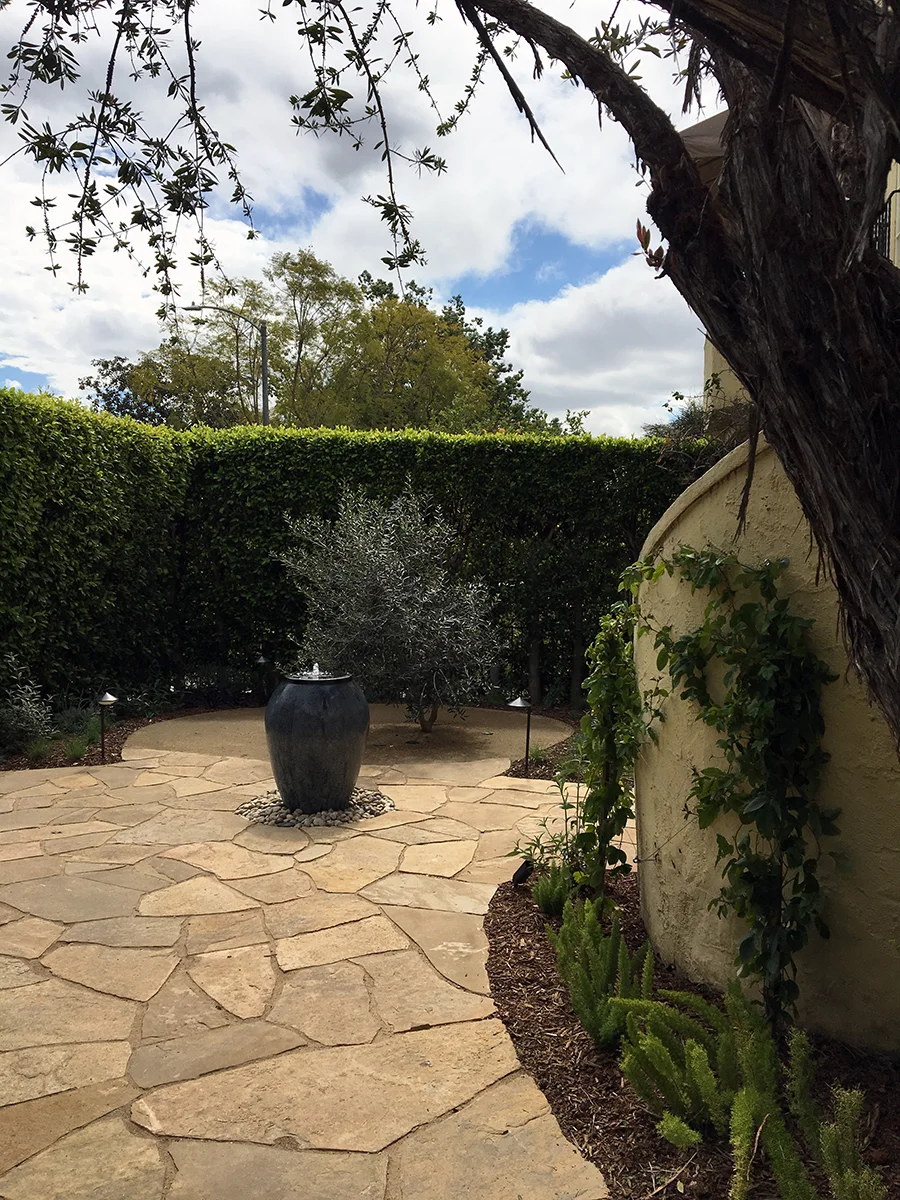 New courtyard entry with hardscape, fountain, and lighting.