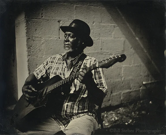 Blues artist McKinney “Blues Man” Williams plays in front of the famous Blue Front Cafe in Bentonia, MS.