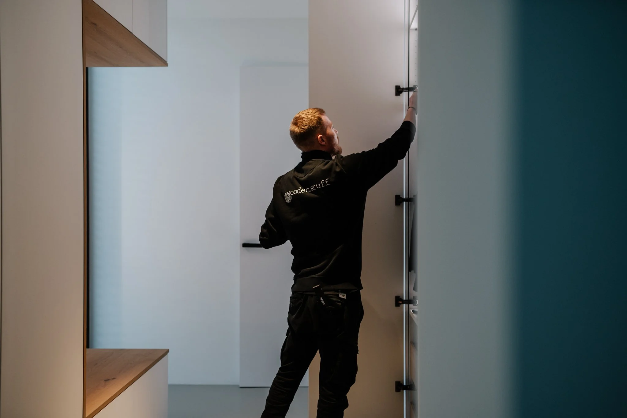 Mann beim Möbelaufbau in einem modernen, hellen Raum