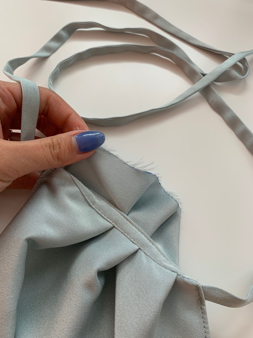 Strap sewn into the top neckline, top stitched to the pleats and yoke.