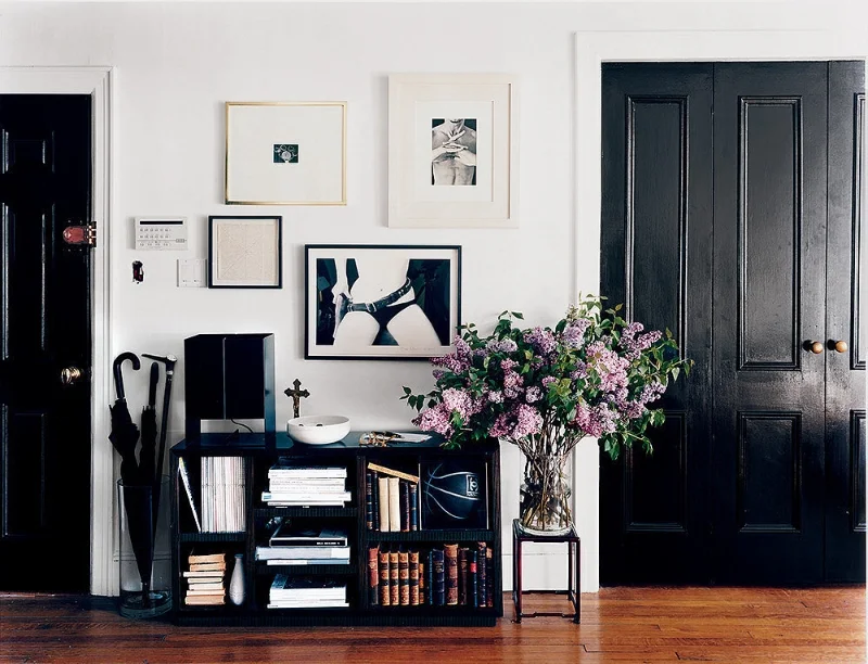 Looking to make a bold statement? Give your doors a makeover with glossy dark paint. The moody hue will add contrast and sophistication to a neutral space. Via Domino