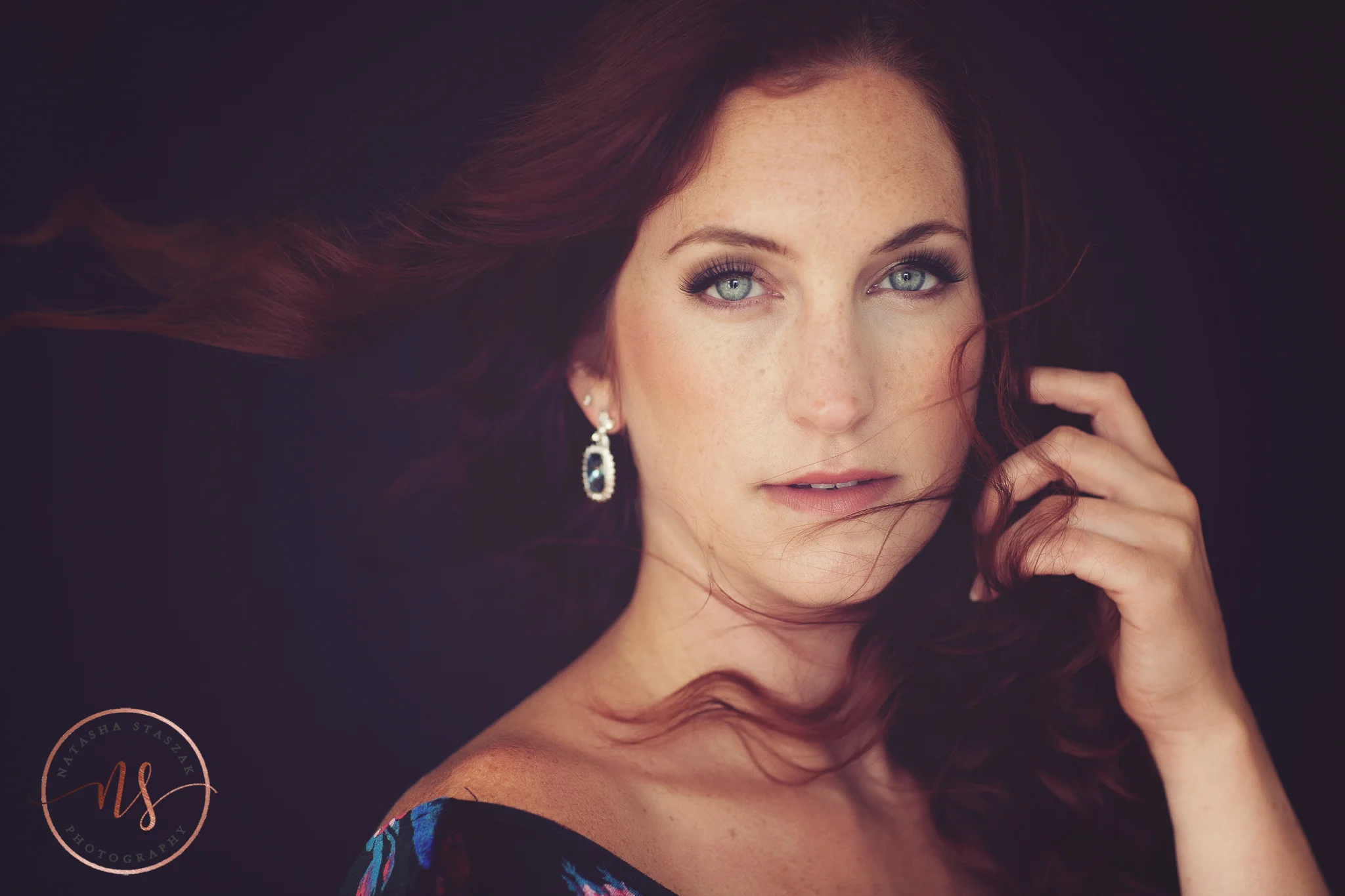 Portrait of Cortney Chyme with red hair blowing close up in Buffalo NY