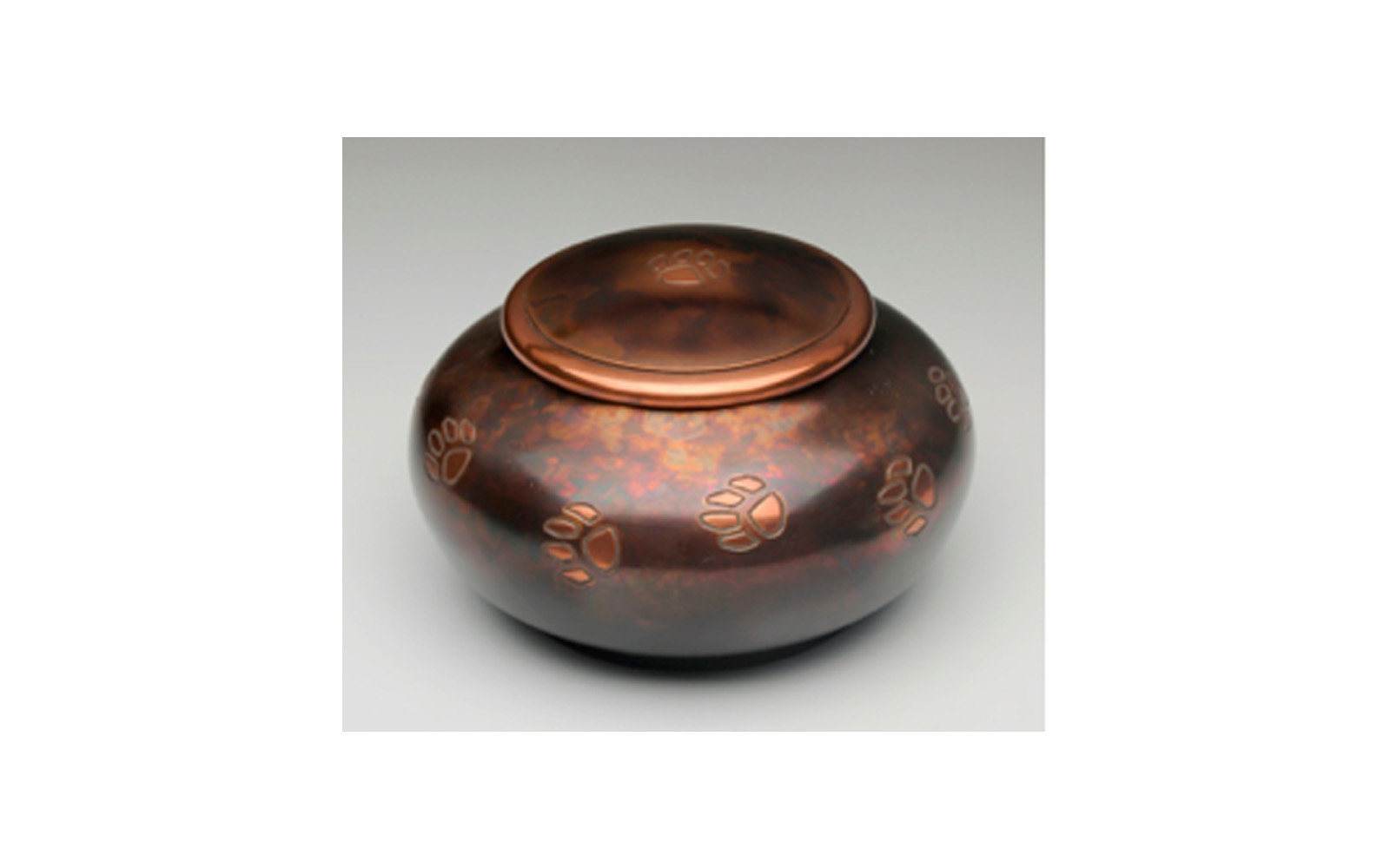 Milano Raku Paw Print Made of a Beautiful Brass with a Copper Overlay and a Raku Finish. This urn has a Threaded Lid and a Felt-Lined Base. This urn comes in Large, Medium, and Small sizes. Large: Measures 4.75” L x 7.25” W x 7.25” H, 100 Cu. Inches, up to 95 lbs., $78 Medium: Measures 4” L x 6.5” W x 6.5” H, 70 Cu. Inches, up to 65 lbs., $60 Small: Measures 5.5” L x 5.5” W x 3.25” H, 45 Cu. Inches, up to 40 lbs., $50
