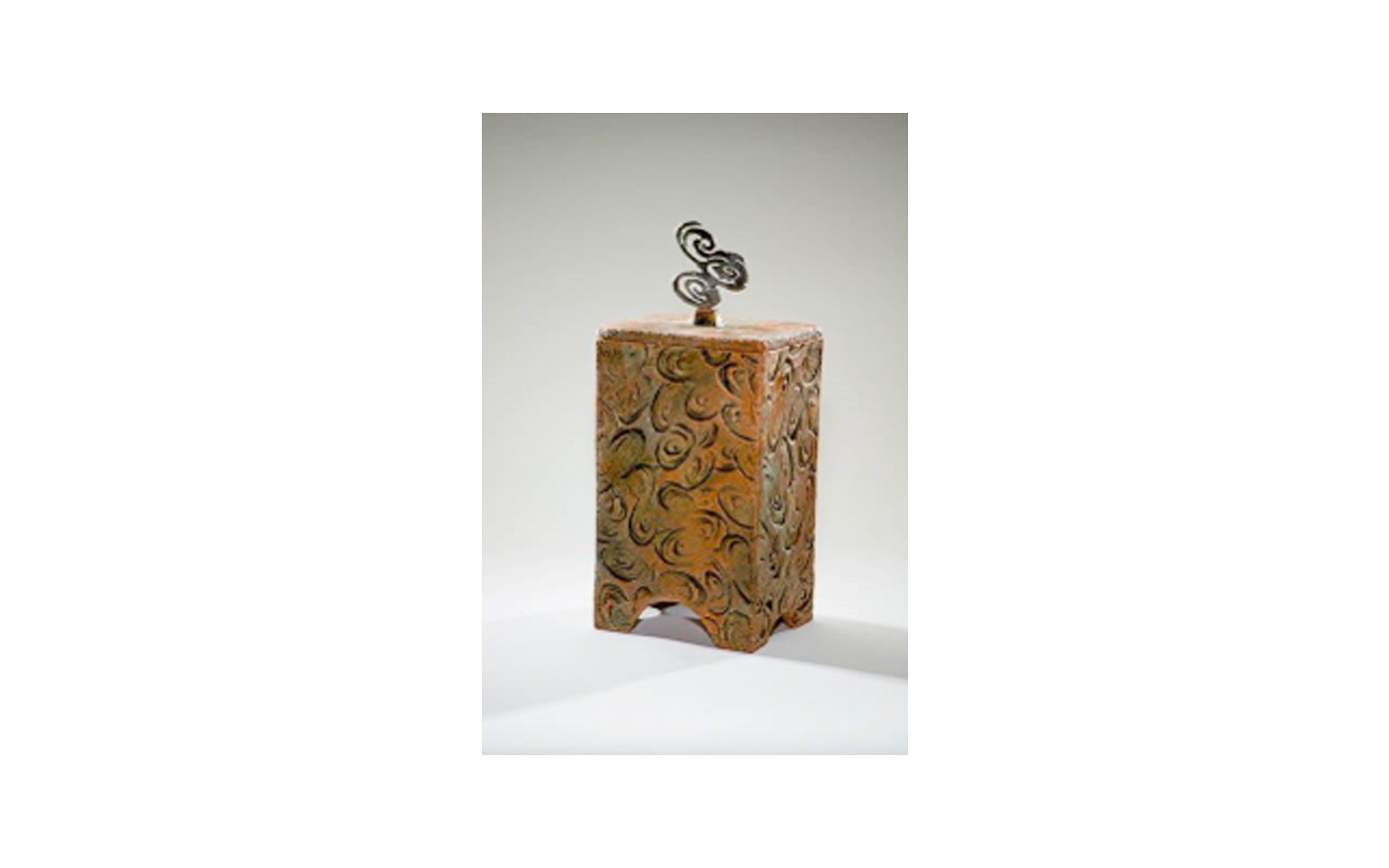 Tempo Ceramic Urn This ceramic urn has a steel designed handle that was used by the Artist to create the impressions on the sides of it. This urn measures 6 ¾” L x 6 ½” W x 15” H and holds 225 Cu. Inches, up to 225 lbs. $635 *Please Note: Each piece is uniquely made by its Artist resulting in different colors and weight