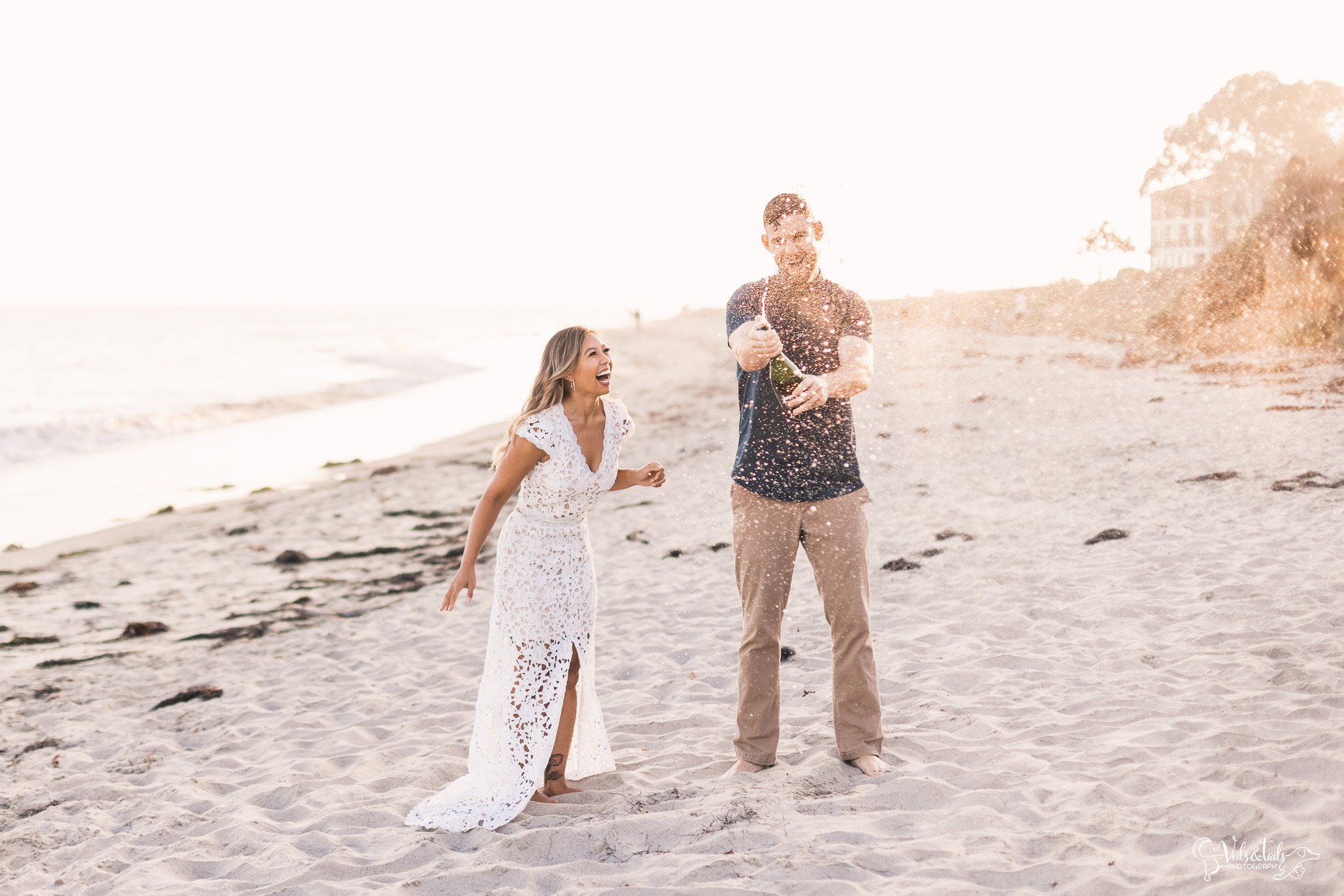 Santa Barbara beach engagement wedding photographer champagne splash
