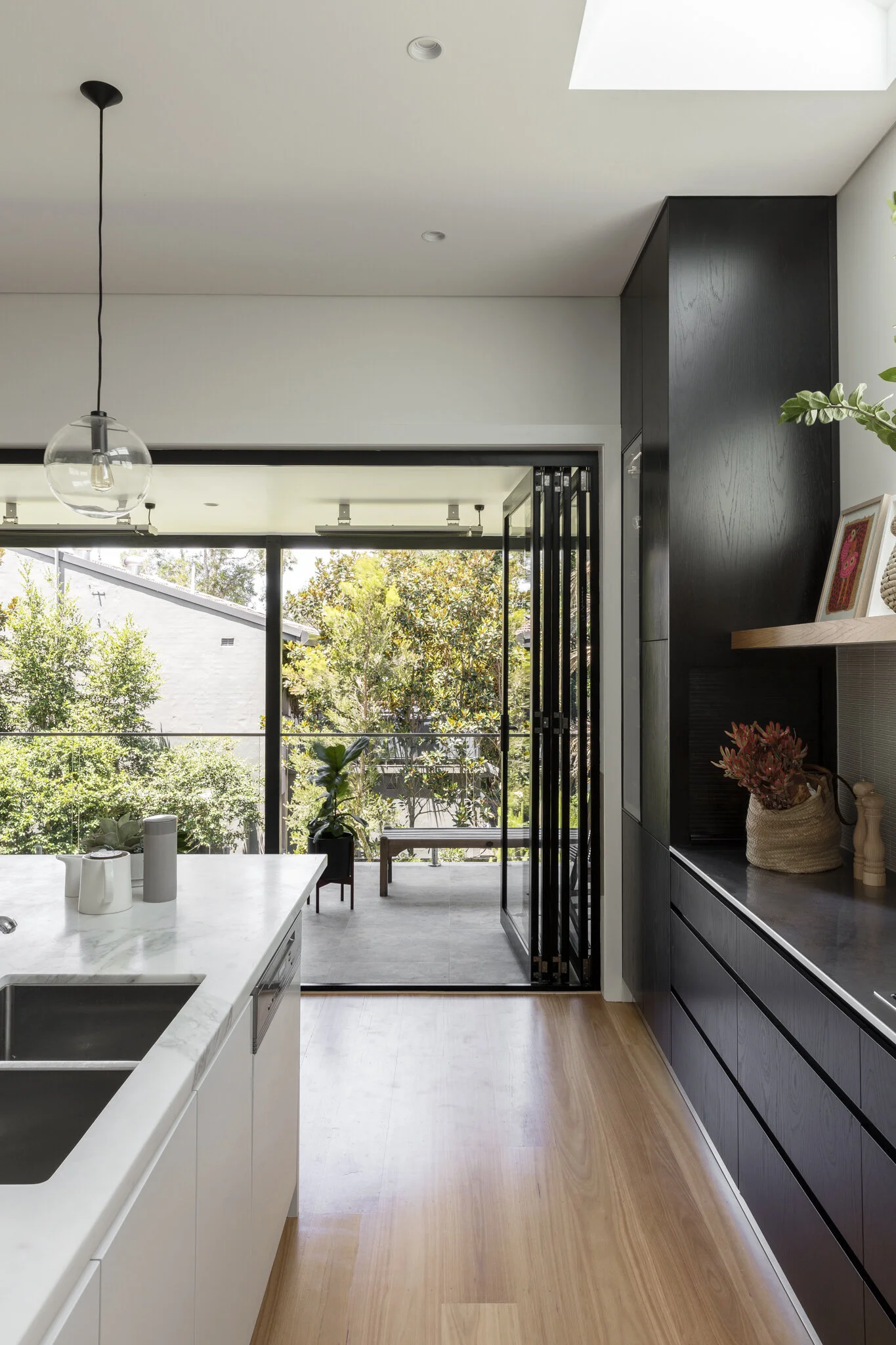 The kitchen opens out to a verandah space over the tree canopy.