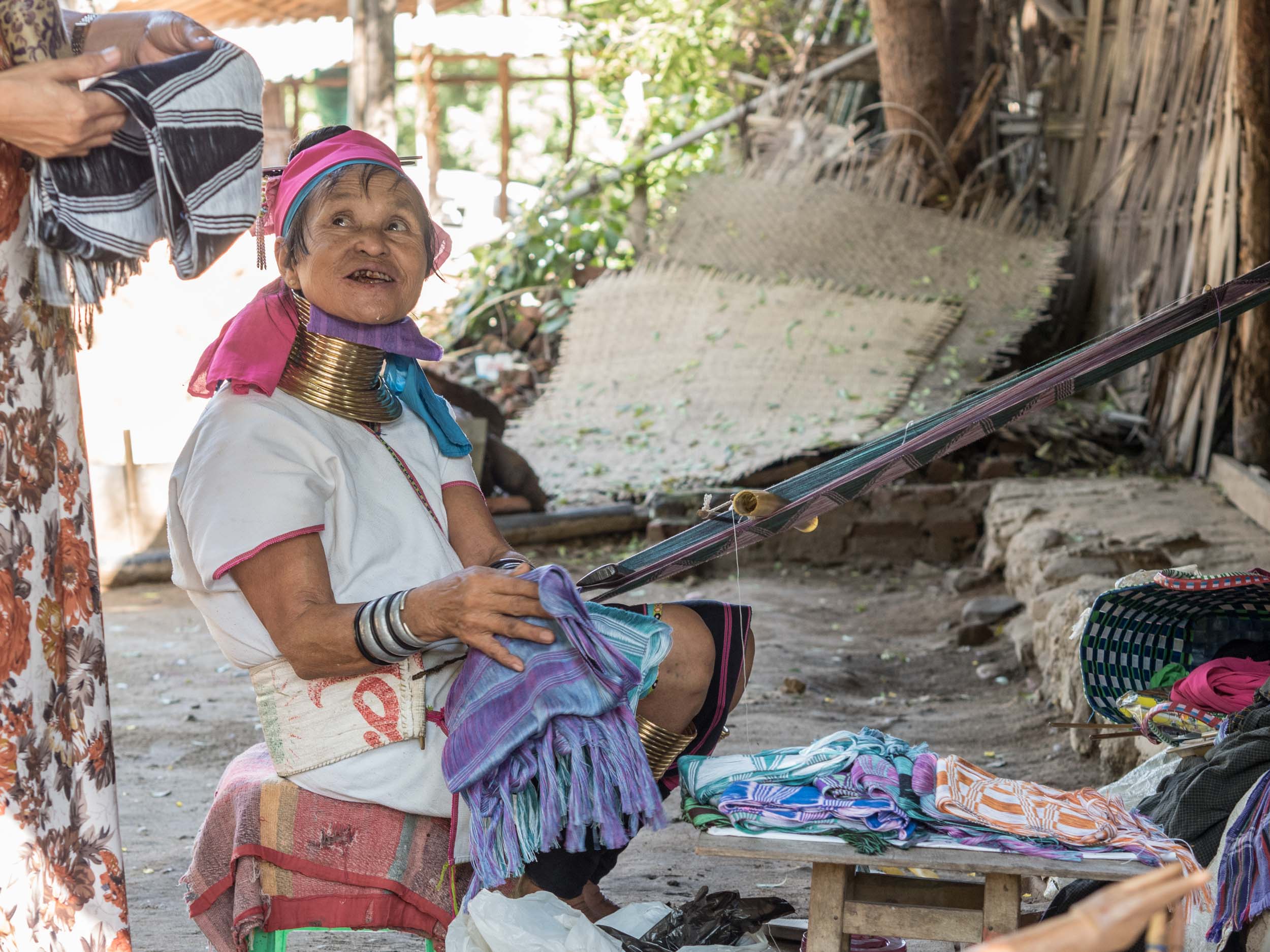 Long neck tribeswoman carrying out textile work.