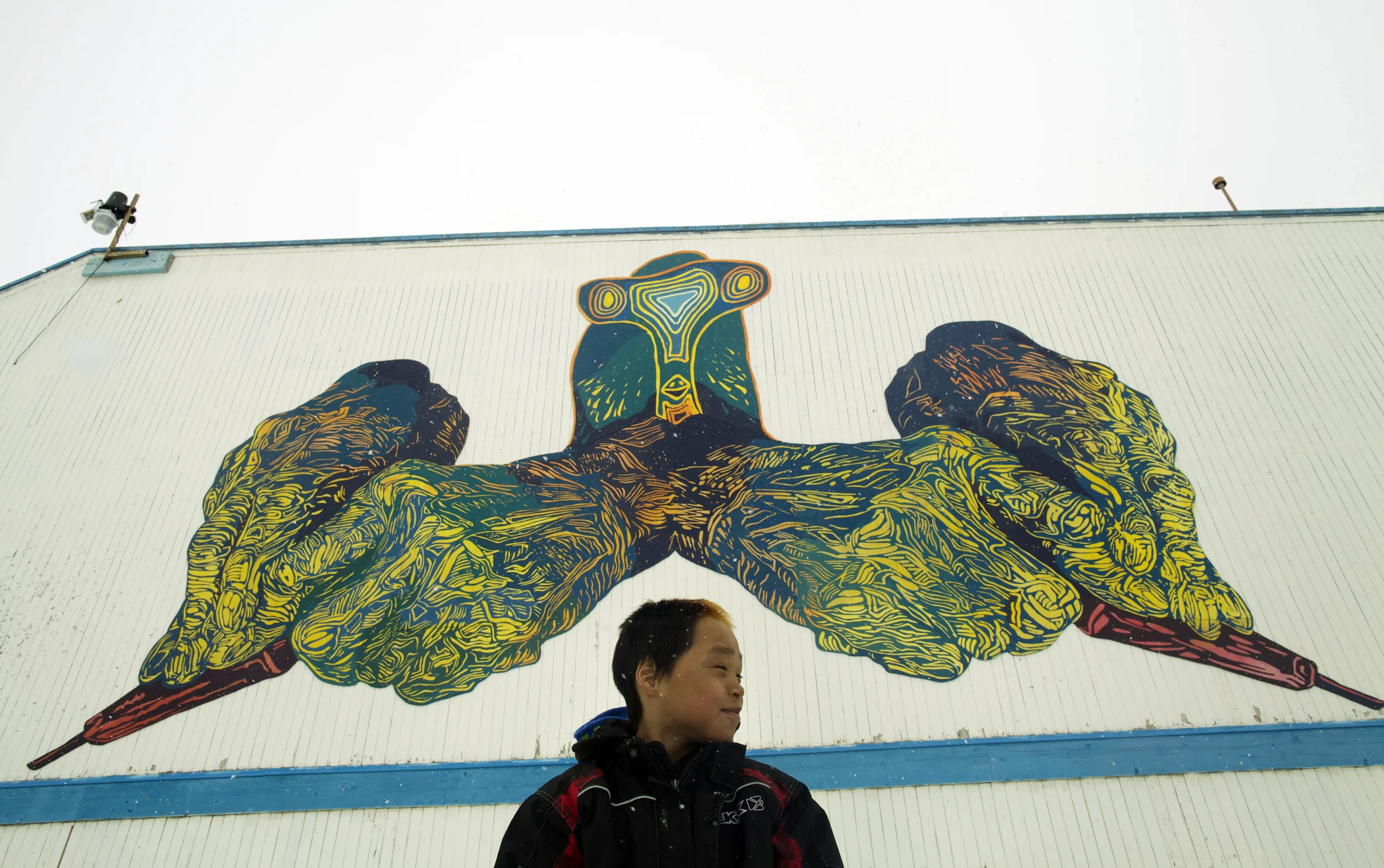 MINE YOUR IMAGINATION, Cape Dorset, Nunavut, Canada, 2014-2015 18x36', latex on mounted plywood We created the hans in the mural by making original linocut prints, and projecting and painting them cut-for-cut: our way of giving a nod to the inspiring printmaking in Cape Dorset, past and present. The bird head was created by Parr Etidloie, 15 years old. ( http://dorsetfinearts.com/aboutus.php)