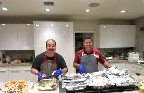 Life-Long friends Joe and Dave prepare dinner (with surgical gloves on)