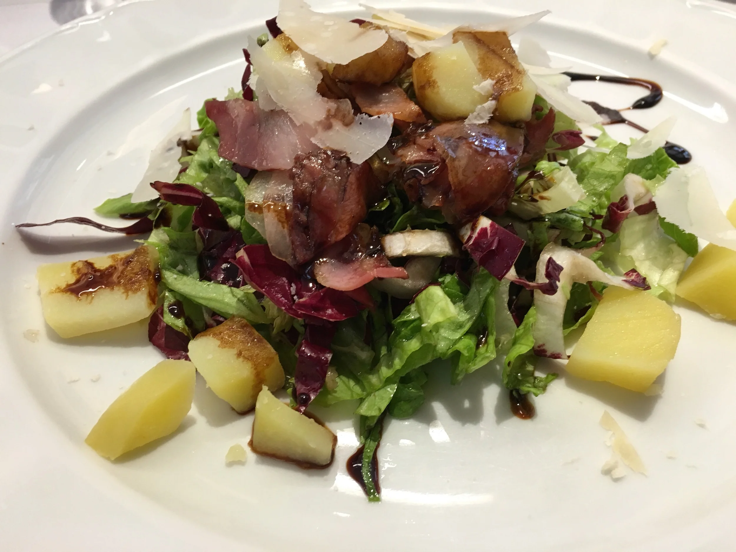Mixed green salad with warm potatoes and speck