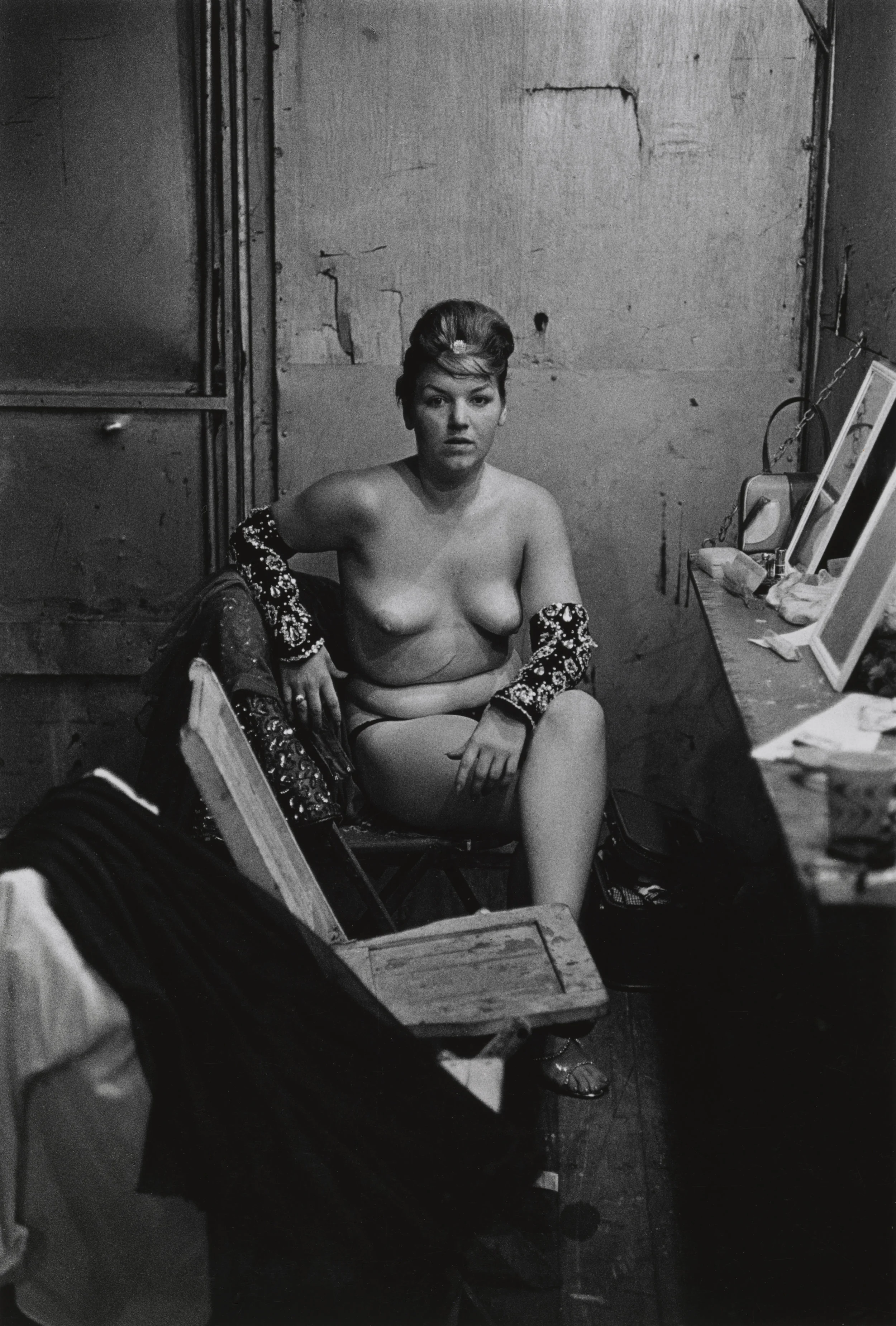 Stripper with bare breasts sitting in her dressing room , N.J. 1961 - Copyright © The Estate of Diane Arbus, LLC. All Rights Reserved.