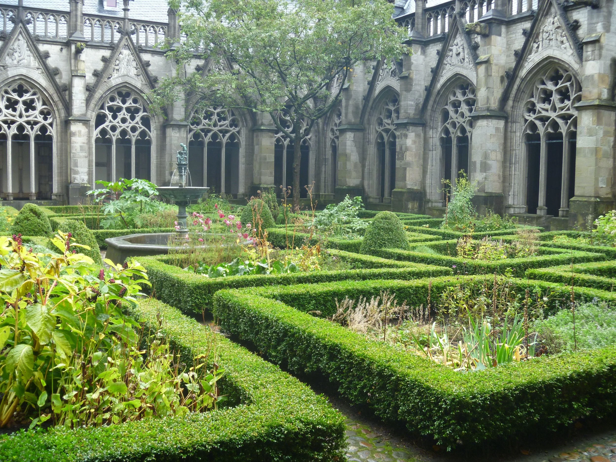 The cloister garden of Sint Agathaklooster is completely enclosed, contains a central sculptural feature and rectangular plots for herbal and decorative plants. 1300's CE. Utrecht, the Netherlands.