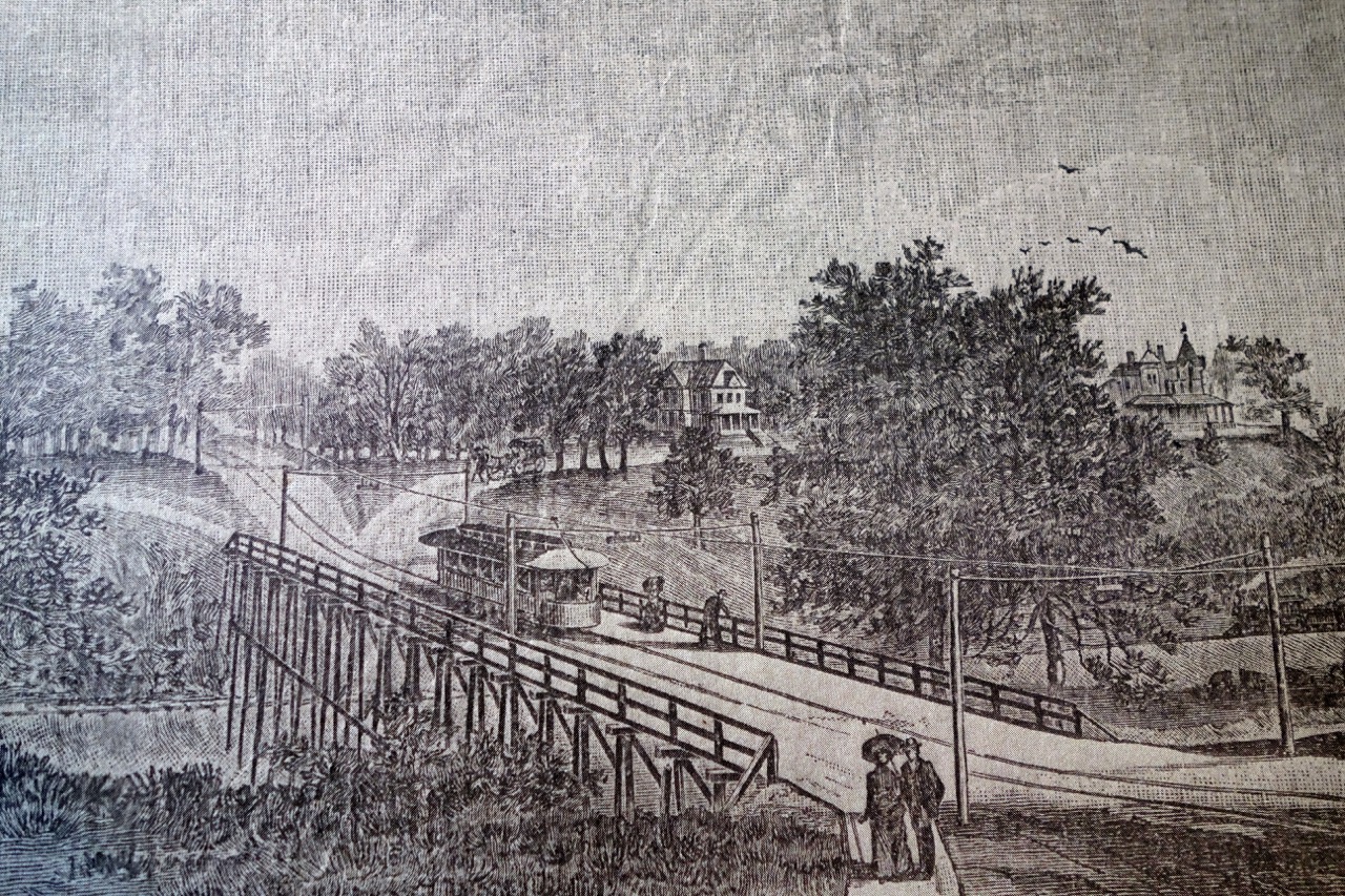Before: An 1890’s lithograph shows the house in the distance set amidst stands of trees and open lawn. The original Fox River bridge was set away from the house. Source: Hearthstone Museum