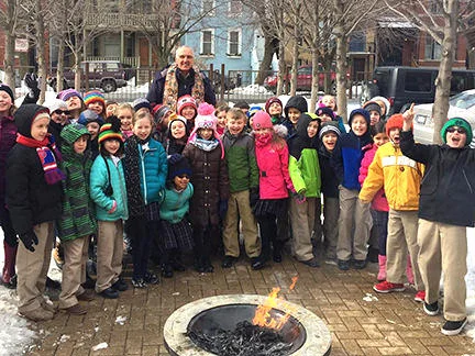 Fr. Larry and ICSJ 2nd Graders burn palm fronds.
