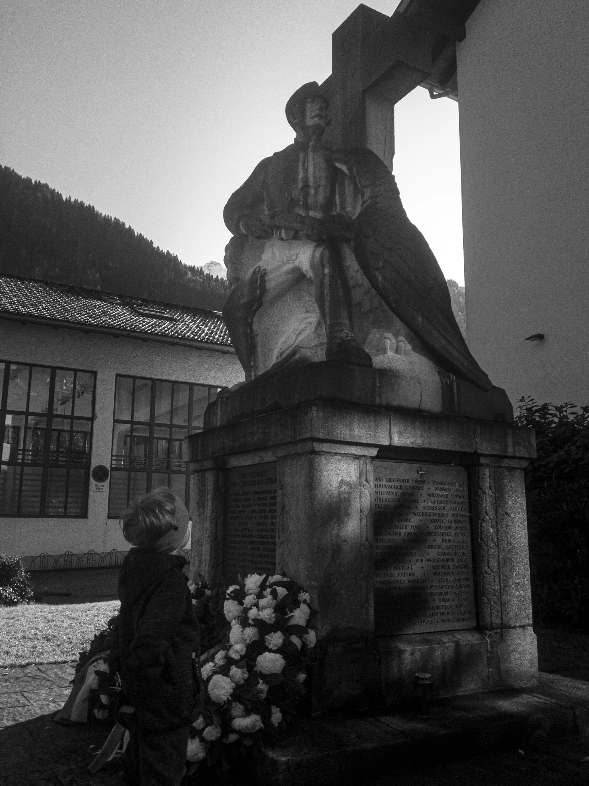 my youngest reading the names on the memorial, they are 100 years old but still the same as today.