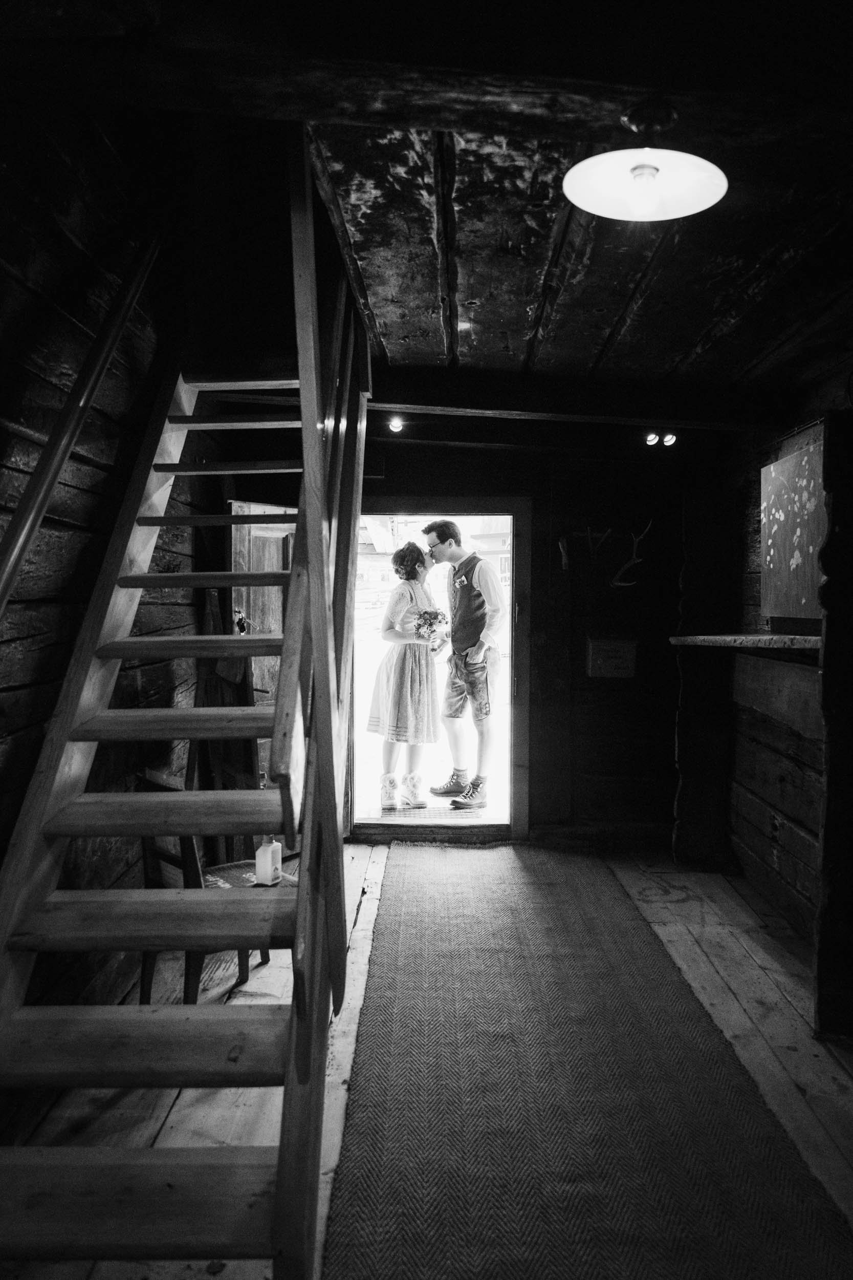 Brautpaar küsst sich am Eingang des Zillertaler Traditionshauses.jpg