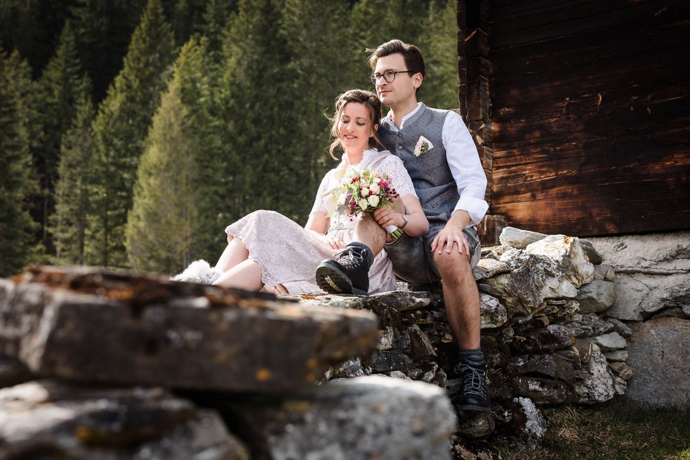 Hochzeitspaar sitzt auf Trockenmauer.jpg