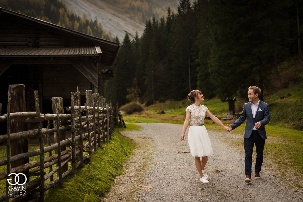 Hochzeitspaar das einen Alpenweg entlang geht.jpg