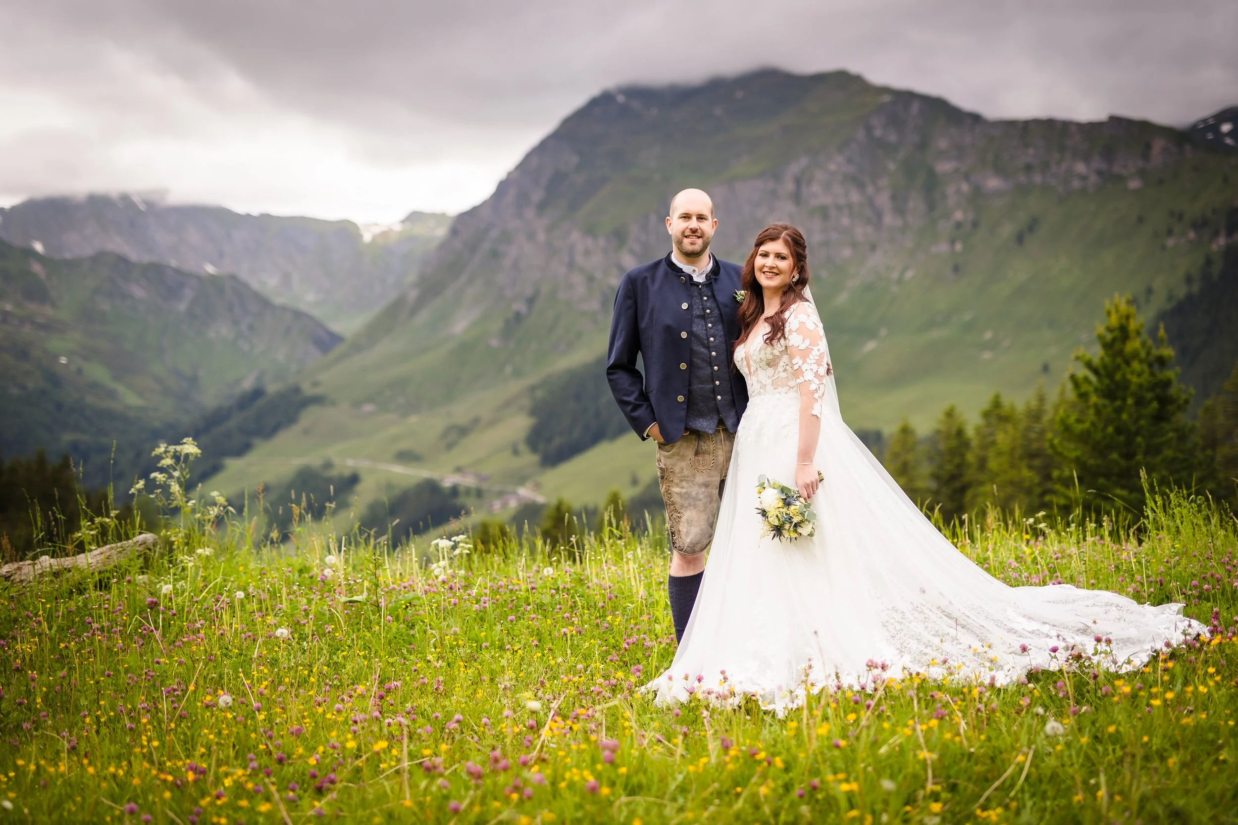 bridal couple in meadow in the mountains on a rainy day