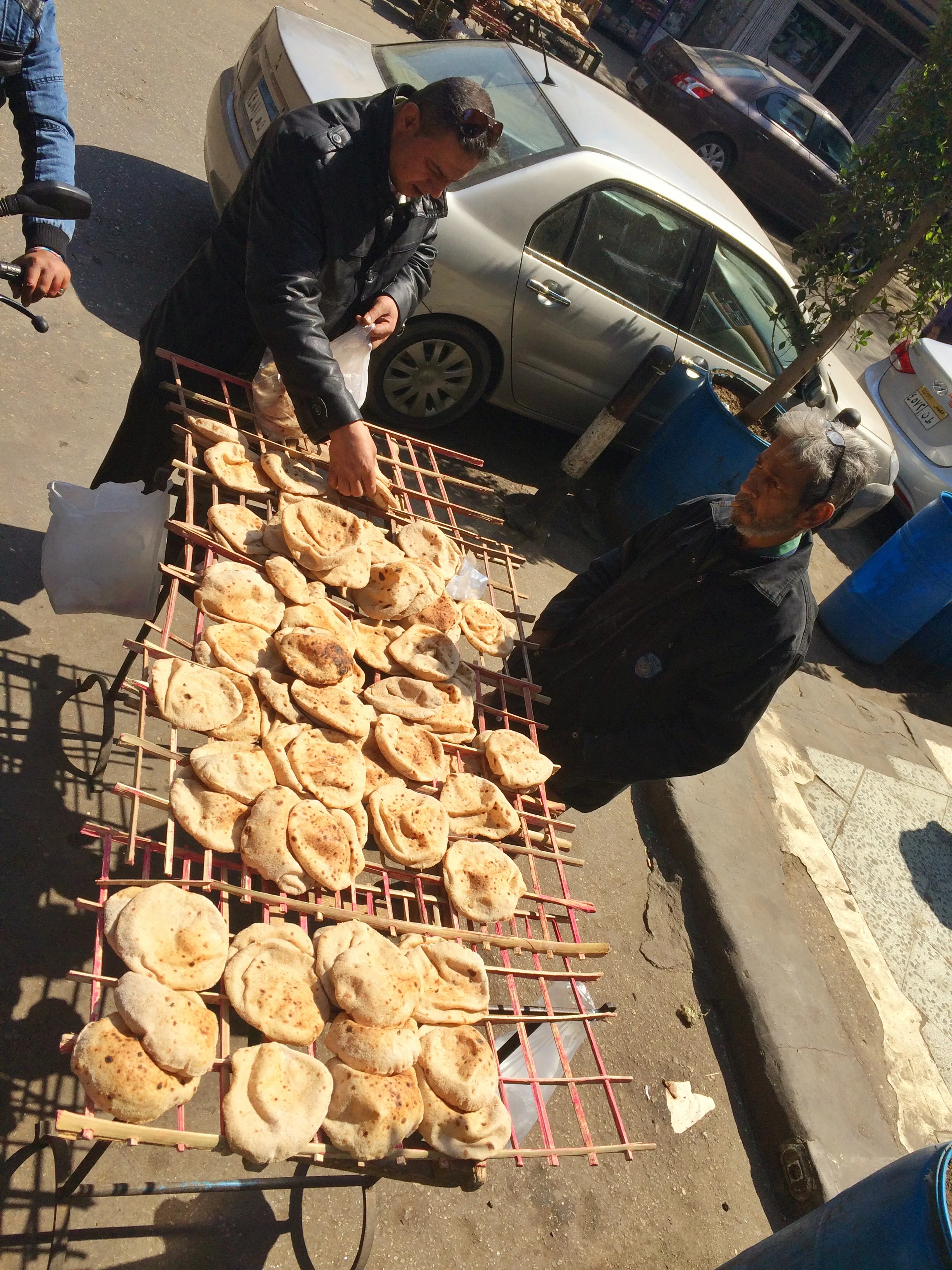 Buying pita bread outside Koshary Abou Tarek in Cairo