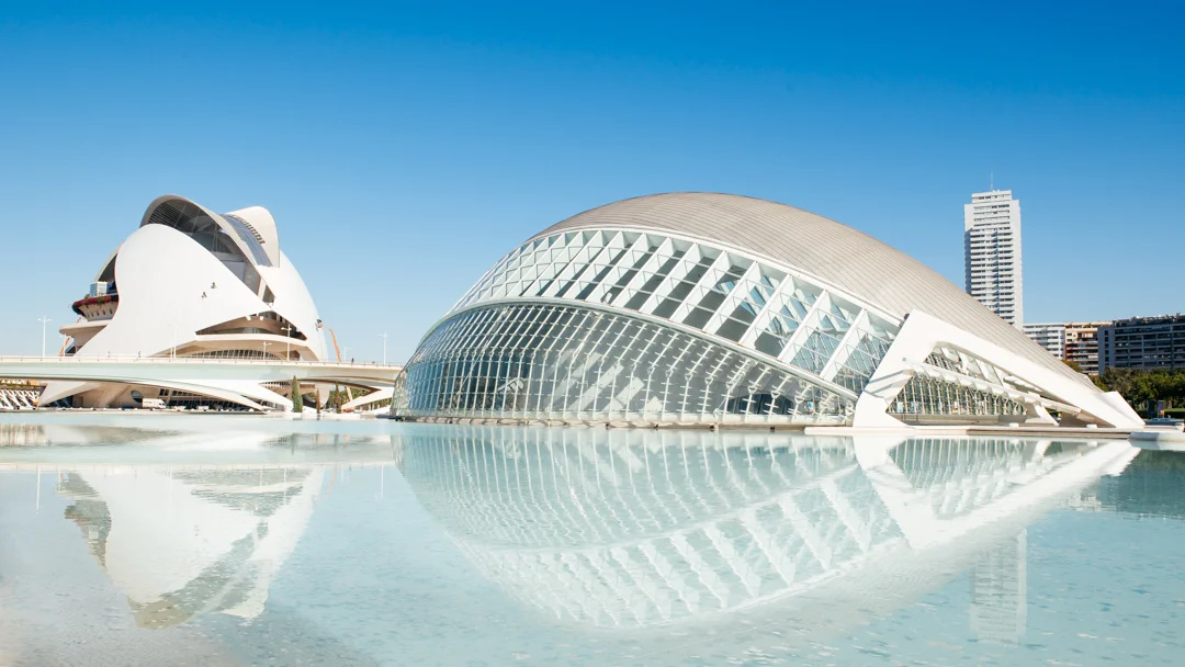 A view of the L'Hemisfèric (right) , which is designed to look like a half-opened eye, and home to a massive IMAX Theater. Behind the L'Hemisfèric is the opera and performing arts center called the El Palau de les Arts Reina Sofía (left) . 